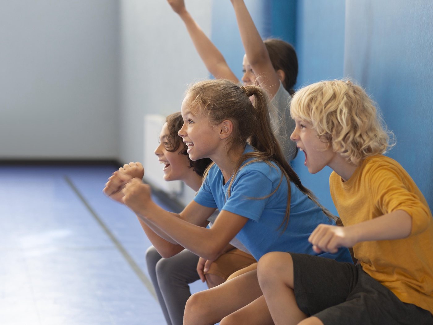 Des jeunes côte à côte, poings serrés, encourageant ensemble depuis un gradin